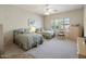 Bright bedroom with two beds, neutral carpet, a ceiling fan, and plantation shutters for natural light at 7654 E Quill Ln, Scottsdale, AZ 85255