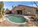 Backyard pool with desert landscaping, stone surround, and patio with partial shade from the home at 7654 E Quill Ln, Scottsdale, AZ 85255