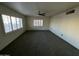 Large living room with carpet, ceiling fan, and multiple windows at 801 W Earll Dr, Phoenix, AZ 85013