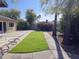 A serene backyard featuring a patio, lush lawn, mature trees, and a privacy fence at 903 W Loughlin Dr, Chandler, AZ 85225