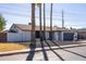 Single story home featuring white brick, a dark garage door, desert landscaping, and three palm trees at 941 W Peralta Ave, Mesa, AZ 85210