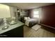 Spacious bedroom with a queen-size bed and dark-red accent wall at 9431 E Coralbell Ave, Mesa, AZ 85208