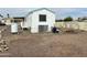 Rear view of a white manufactured home with AC unit and gravel yard at 9431 E Coralbell Ave, Mesa, AZ 85208