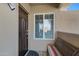 Condo entry with a brown door, window, and striped bench at 10101 N Arabian Trl # 2052, Scottsdale, AZ 85258