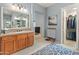 Elegant bathroom with double sinks, large mirror, and walk-in closet at 12519 W Bajada Rd, Peoria, AZ 85383