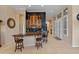 Curved wet bar with wood cabinetry, granite countertop and seating at 12519 W Bajada Rd, Peoria, AZ 85383