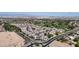 Wide aerial shot of a community with golf course, roundabout, and mountain views in the distance at 14200 W Village Pkwy # 113, Litchfield Park, AZ 85340