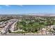 Expansive aerial view showcasing a golf course, residential homes, and distant mountains at 14200 W Village Pkwy # 113, Litchfield Park, AZ 85340