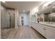 Beautiful bathroom with a walk-in shower, dual sinks, modern fixtures, and a spacious walk-in closet at 14200 W Village Pkwy # 113, Litchfield Park, AZ 85340