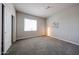 Bright bedroom with plush carpeting, a large window with blinds, neutral walls and a closet with sliding doors at 14200 W Village Pkwy # 113, Litchfield Park, AZ 85340