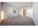 Large bedroom featuring neutral walls, carpet flooring, doorway to walk-in closet, and floor lamp at 14200 W Village Pkwy # 113, Litchfield Park, AZ 85340