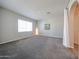 Large bedroom with neutral walls, carpet flooring, a large window, and floor lamp at 14200 W Village Pkwy # 113, Litchfield Park, AZ 85340
