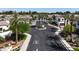 Aerial neighborhood view showing a street roundabout with lush landscaping and mature palm trees at 14200 W Village Pkwy # 113, Litchfield Park, AZ 85340