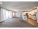 Open-concept living area with a modern kitchen, carpet flooring, and sliding glass doors providing natural light at 14200 W Village Pkwy # 113, Litchfield Park, AZ 85340
