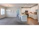 Bright living room features a modern chandelier, neutral paint, carpet, and an open floor plan to kitchen at 14200 W Village Pkwy # 113, Litchfield Park, AZ 85340