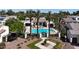 An aerial view showcasing a sparkling pool with lounge chairs and well-maintained landscaping at 14200 W Village Pkwy # 113, Litchfield Park, AZ 85340