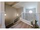 Modern staircase with wood-look tile flooring, wrought iron railing, and decorative lighting at 14200 W Village Pkwy # 113, Litchfield Park, AZ 85340