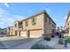 Tan two-story townhome with attached garage and walkway at 1448 N 80Th Dr, Phoenix, AZ 85043