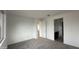 Spacious bedroom with neutral walls, gray carpet, and bathroom access at 15790 W Hackamore Dr, Surprise, AZ 85387