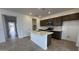 Modern kitchen with island, dark brown cabinets, and quartz countertops at 15790 W Hackamore Dr, Surprise, AZ 85387