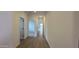 Bright hallway with light wood-look tile floors and doors to other rooms at 15797 W Hackamore Dr, Surprise, AZ 85387