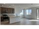 Modern kitchen with island, dark cabinets, and view to backyard at 15797 W Hackamore Dr, Surprise, AZ 85387