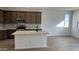 Modern kitchen with dark cabinets, an island, and tile floors at 15797 W Hackamore Dr, Surprise, AZ 85387