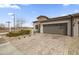 Single-story home with brick facade, two-car garage, and landscaped front yard at 17256 W West Wind Dr, Surprise, AZ 85387