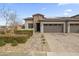 Modern home with brick accents and solar panels. Landscaped front yard and paved driveway at 17256 W West Wind Dr, Surprise, AZ 85387