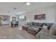 Open living room with gray sectional and adjacent dining area at 17403 W Eagle Ct, Goodyear, AZ 85338