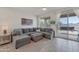 Gray sectional sofa and ottoman in living room with backyard access at 17403 W Eagle Ct, Goodyear, AZ 85338