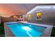 Relaxing pool area at sunset, featuring a spa and outdoor lighting at 17440 W Eugene Ter, Surprise, AZ 85388