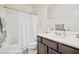 Clean bathroom with dark vanity, shower/tub combo, and white linens at 17673 W Agave Rd, Goodyear, AZ 85338