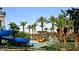 Large community pool with waterslide and palm trees at 17673 W Agave Rd, Goodyear, AZ 85338