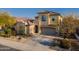 Two-story house with tan exterior, tile roof, and a three-car garage at 17673 W Agave Rd, Goodyear, AZ 85338