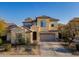 Two-story house with tan exterior, tile roof, and a three-car garage at 17673 W Agave Rd, Goodyear, AZ 85338
