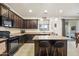 Spacious kitchen with island, dark cabinetry, and granite countertops at 17673 W Agave Rd, Goodyear, AZ 85338