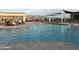 Community pool with surrounding lounge chairs and mountain views at 17673 W Agave Rd, Goodyear, AZ 85338