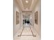Long hallway with tile flooring, crown molding, and framed artwork at 17918 N 95Th St, Scottsdale, AZ 85255