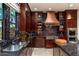 Kitchen with copper range hood, granite counters, and dark wood cabinets at 17918 N 95Th St, Scottsdale, AZ 85255