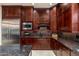 Modern kitchen with dark wood cabinets, granite countertops, and a large island at 17918 N 95Th St, Scottsdale, AZ 85255
