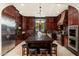 Island kitchen with dark wood cabinets, granite counters, and stainless steel appliances at 17918 N 95Th St, Scottsdale, AZ 85255