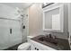 Bathroom with a glass-enclosed shower and a dark vanity, offering a modern and elegant space at 2161 E Flintlock Way, Chandler, AZ 85286