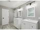 Bright bathroom featuring dual vanities, modern lighting, and light-colored tile flooring and walls at 2161 E Flintlock Way, Chandler, AZ 85286