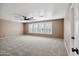 Bright bedroom with beige walls, plush carpeting, ceiling fan, and shuttered windows for natural light at 2161 E Flintlock Way, Chandler, AZ 85286