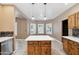 Bright kitchen features an island with white countertop and wood cabinets, and lots of natural light at 2161 E Flintlock Way, Chandler, AZ 85286