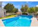 Backyard pool with pristine water and lawn, shaded by trees and tiki umbrellas at 2161 E Flintlock Way, Chandler, AZ 85286
