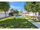 Backyard showcasing a sparkling pool with tiki umbrellas and well-maintained artificial turf, creating an inviting oasis at 2161 E Flintlock Way, Chandler, AZ 85286
