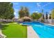 A luxurious pool surrounded by lush greenery and patio umbrellas at 2161 E Flintlock Way, Chandler, AZ 85286