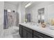 Modern bathroom with double vanity, gray cabinets, and a walk-in shower at 23311 N 95Th Dr, Peoria, AZ 85383